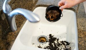 Someone dumping coffee grounds in their drain