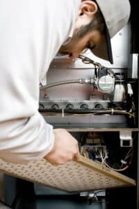 repairman changing furnace filter