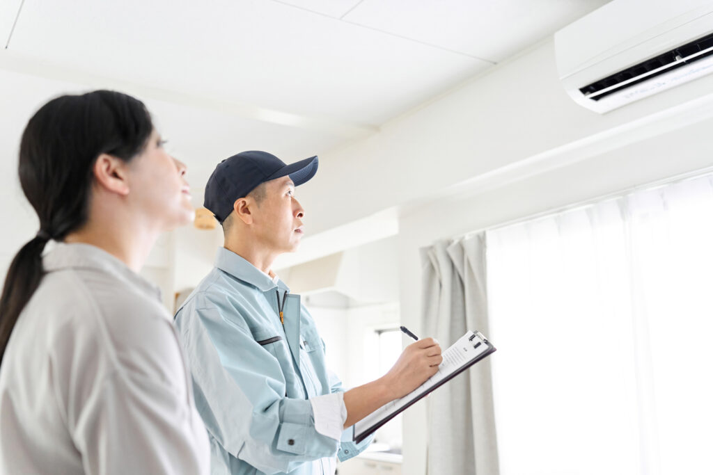 A technician and customer checking a ductless mini-split in a home.