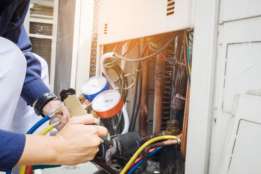 Technician checking HVAC system pressure gauges